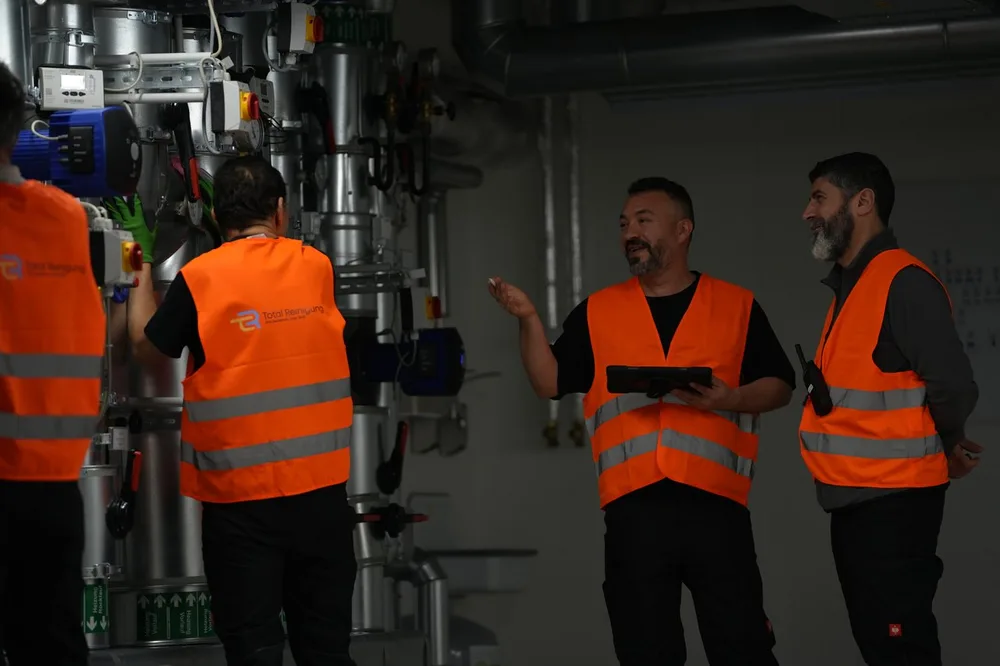 Reinigungsteam in Warnwesten bei der Absprache im Technikraum